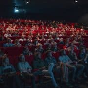 People in a movie theater watching a film on screen