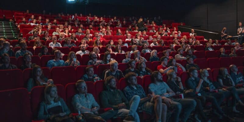 People in a movie theater watching a film on screen